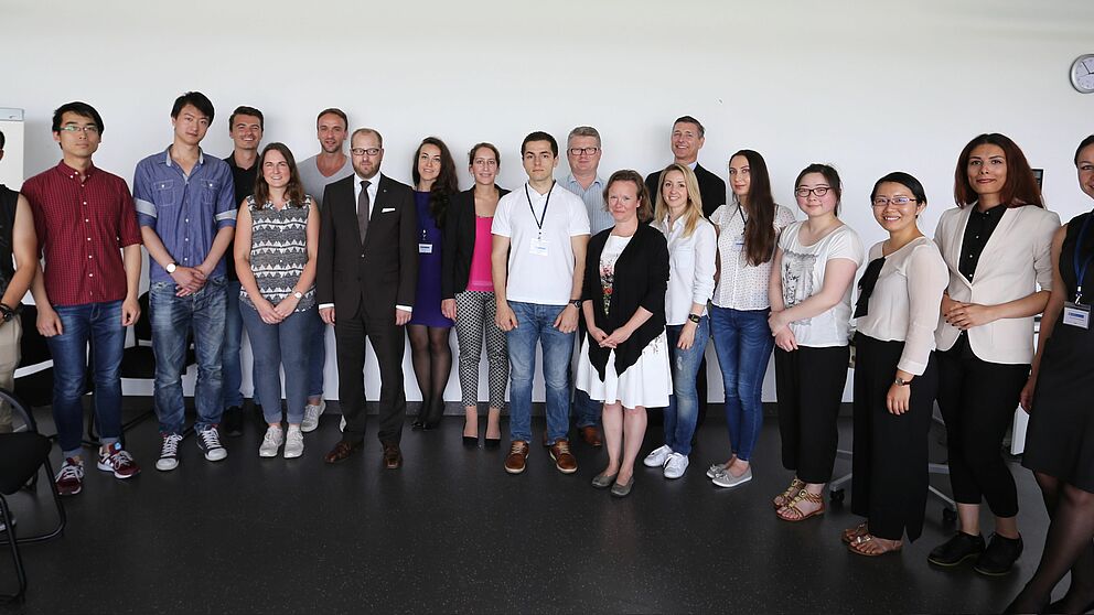 Foto (Universität Paderborn): Ausländische Studierende arbeiten für die heimische Wirtschaft. Ihre Auftraggeber und Betreuer sind: Volksbank-Personalleiter Stefan Müller (7. v. l.), International Office-Leiter Stefan Schwan (11. v. l.), Professorin Dr
