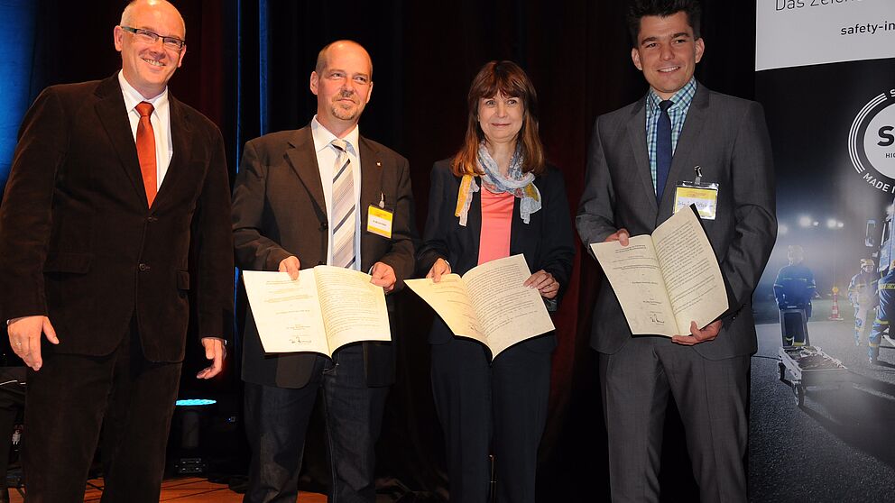 Foto (Friedrich Kulke, Feuerwehr Hamm): Dirk Aschenbrenner (Präsident der vfdb e. V.) zeichnete (v. l.) Dr. Michael Neske (Institut der Feuerwehr Sachsen-Anhalt), Sabina Kaczmarek (Berliner Feuerwehr), Dr.-Ing. Jens Pottebaum (Universität Paderborn) und