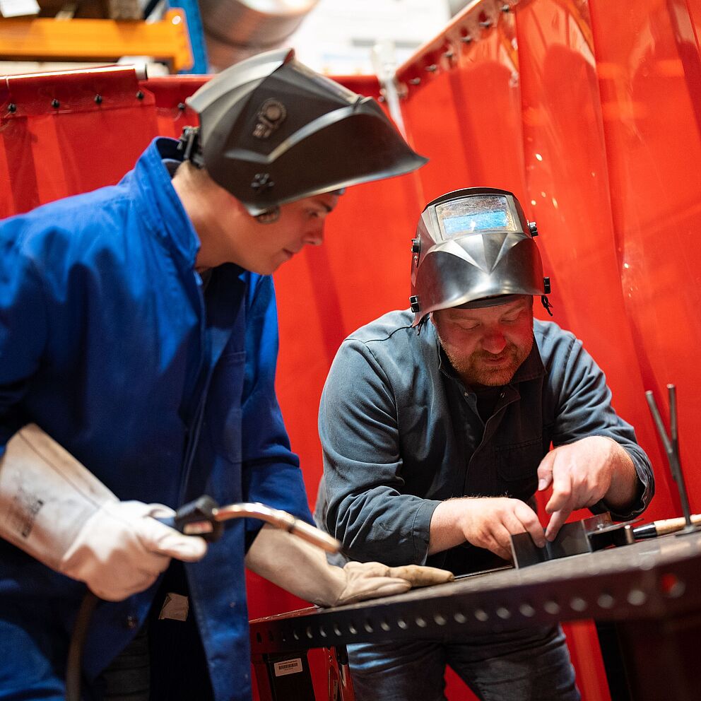 Zwei Studierende schweißen in der Werkstatt