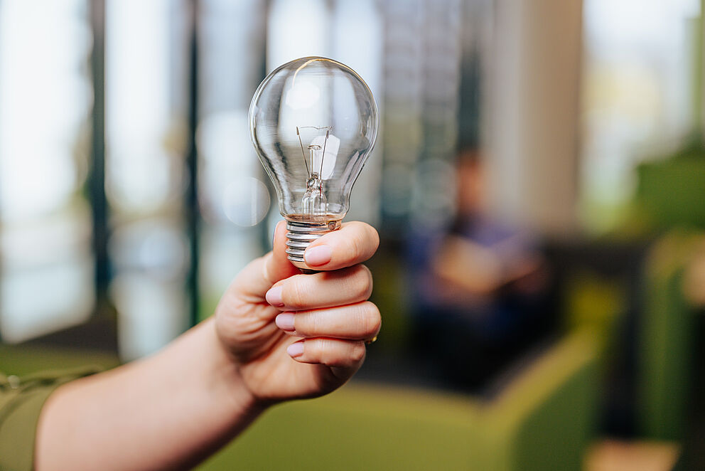 Glühbirne wird in den Raum gehalten 