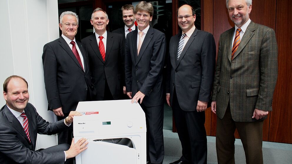 Foto: Freuten sich gemeinsam über die neue Projektgruppe, die unter anderem an der Weiterentwicklung solcher vollautomatischer Wäschetrockner arbeiten wird (v. l.): Dr. Markus Miele von der Miele & Cie. KG, Prof. Dr. Hans-Jörg Bullinger, Präsident der
