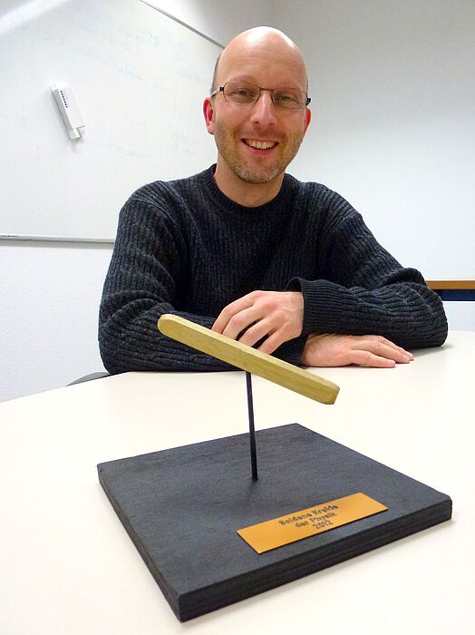Foto (Universität Paderborn): Glücklicher Preisträger der „Goldenen Kreide 2012“: Der Physiker Dr. Matthias Reichelt