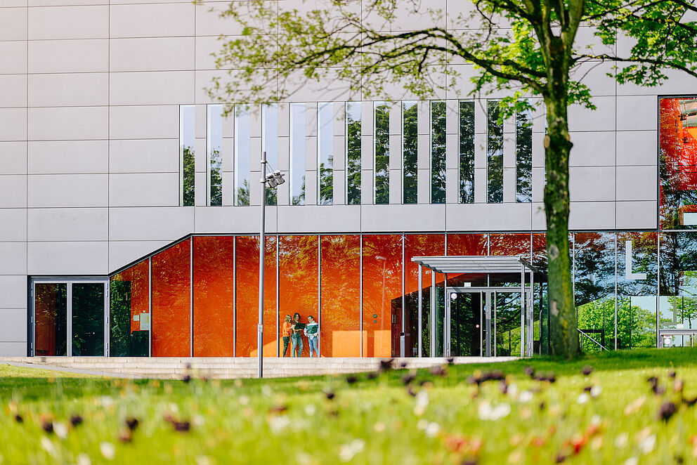 Gebäude L mit Wiese und Baum im Vordergrund 