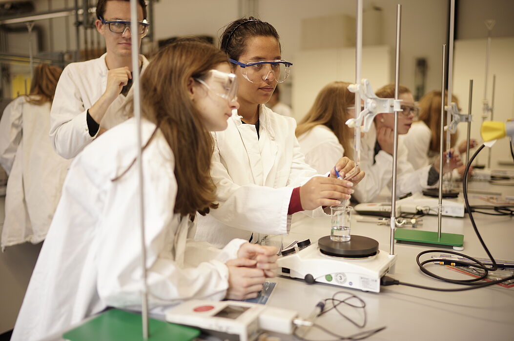 Foto (Universität Paderborn): Wie die Profis: Unter fachgerechter Anleitung durften die Teilnehmerinnen der Herbst-Uni im Chemielabor selbst experimentierten.