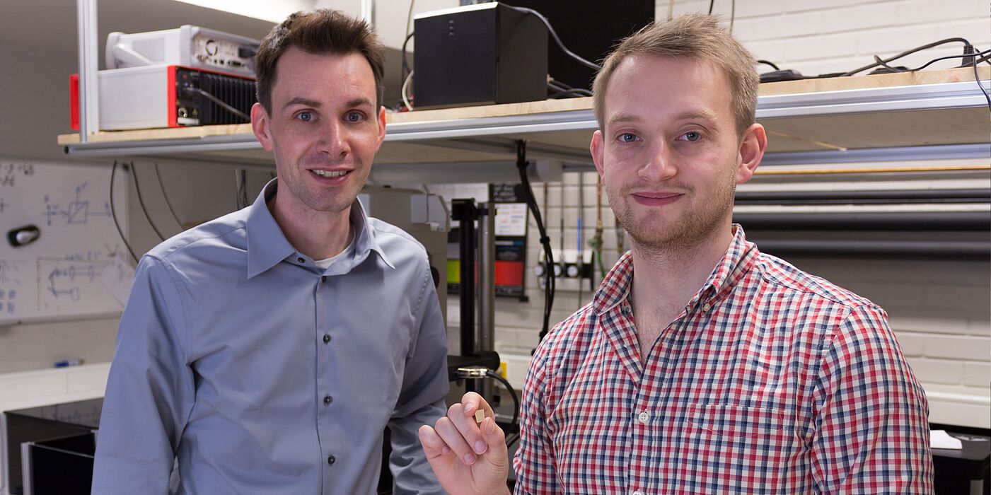 Bild (Department Physik): Prof. Dr. Thomas Zentgraf (links) und Masterstudent Bernhard Reineke (rechts) präsentieren im Optiklabor ihr entwickeltes nichtlineares optisches Material.