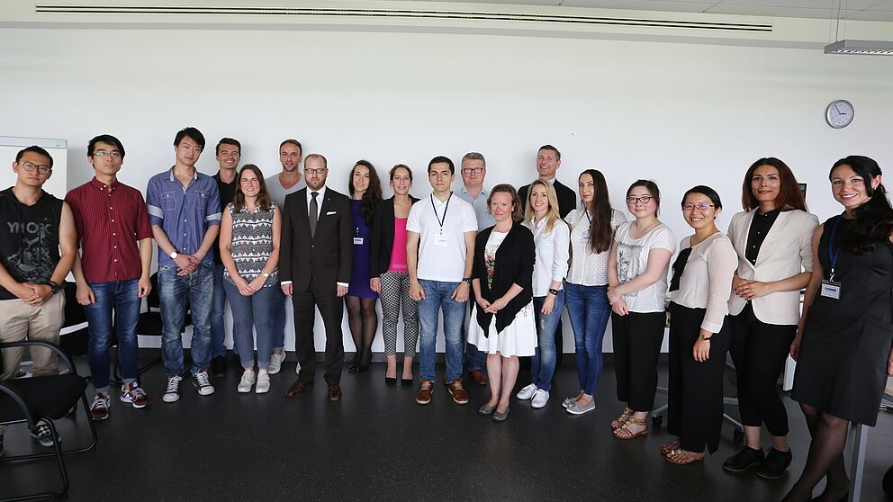 Foto (Universität Paderborn): Ausländische Studierende arbeiten für die heimische Wirtschaft. Ihre Auftraggeber und Betreuer sind: Volksbank-Personalleiter Stefan Müller (7. v. l.), International Office-Leiter Stefan Schwan (11. v. l.), Professorin Dr