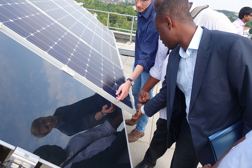 Foto (Universität Paderborn): Das Kooperationsprojekt bietet Beratung für afrikanische Jungunternehmer im Bereich der erneuerbaren Energien und Energieeffizienz an. Hier betrachten sie eine Photovoltaikanlage.