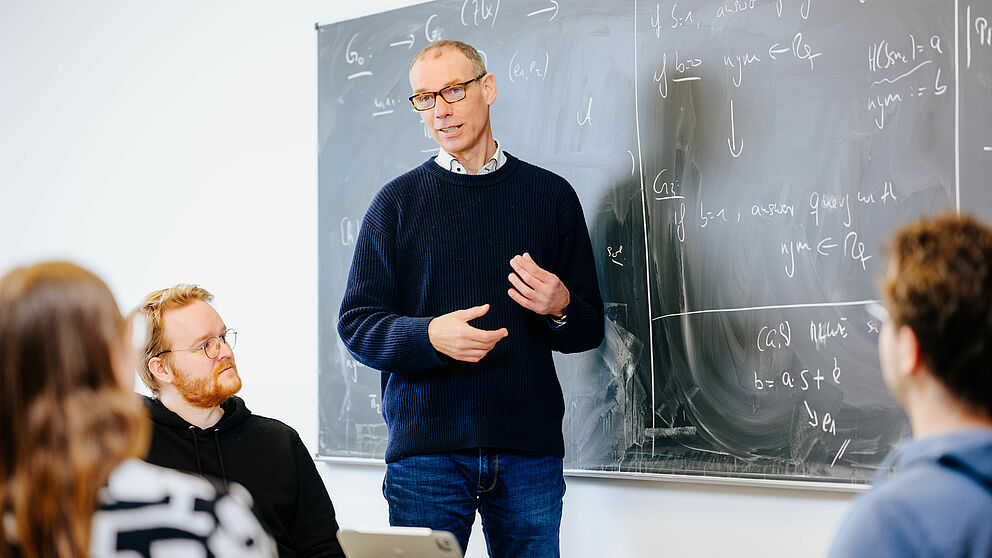 Prof. Dr. Johannes Blömer lehrend vor einer Tafel.